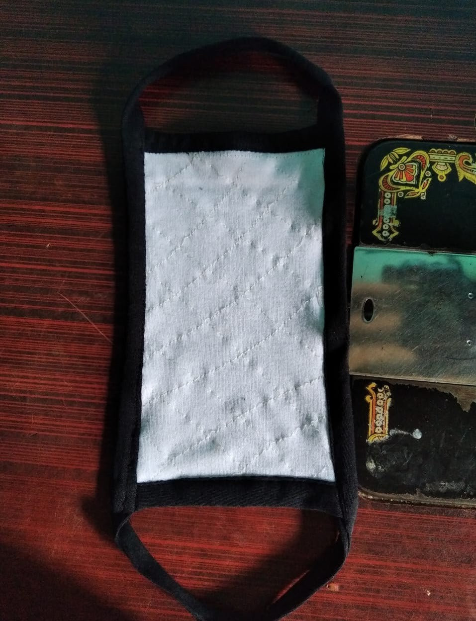 A finished mask beside the sewing machine