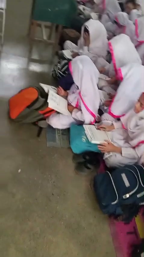 Before, girls reading on bare concrete with only a thin mat